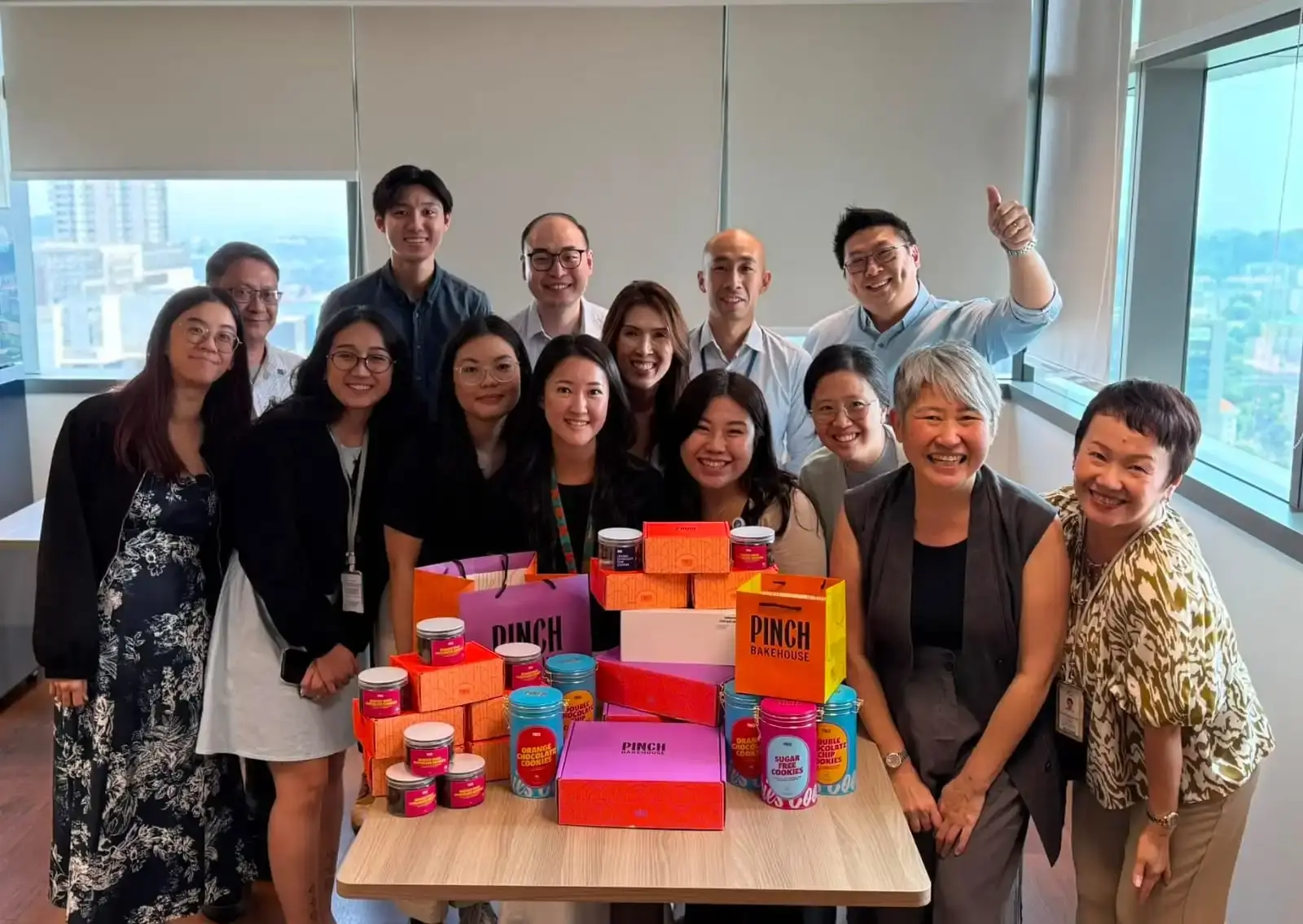 SingHealth and Pinch Bakehouse team members with halal dessert gift boxes after the NCCS fundraising event